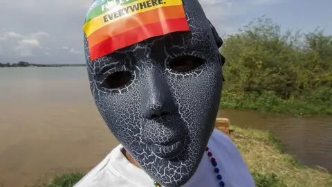 AFP Person with a mask on and a rainbow sticker