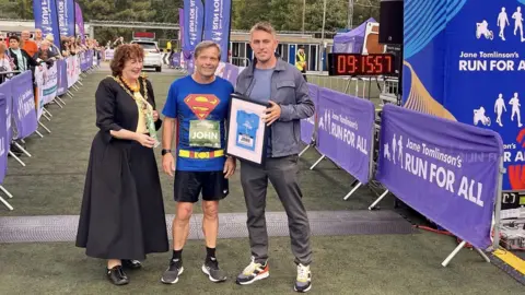 Kevin Ward John Thurkettle (centre) at the start of the race with Ipswich's mayor Lynne Mortimer and Ipswich Town FC manager Kieran McKenna