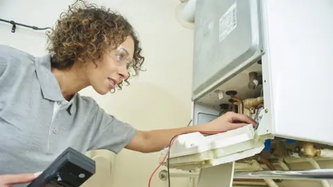 Getty Images Engineer inspecting a boiler