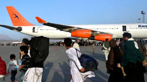 WAKIL KOHSAR family in Afghanistan walking to plane