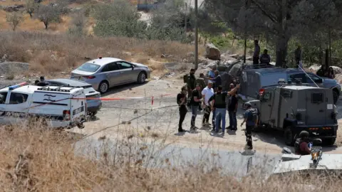 Reuters Israeli security forces inspect the scene of a deadly shooting attack south of Hebron, in the occupied West Bank (21 August 2023)