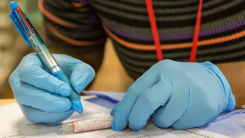 Getty Images Health worker with sample tube