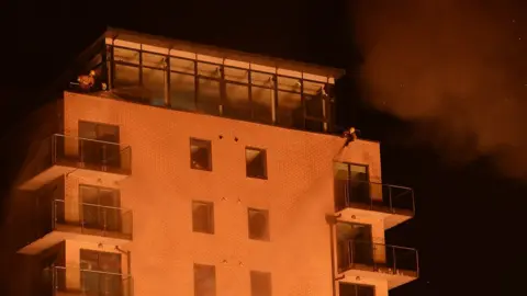 Pacemaker Fire crews sprayed water on the apartment block to prevent the fire spreading