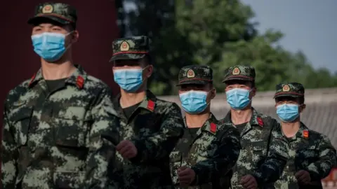 Getty Images PLA troops march with face masks on in Beijing
