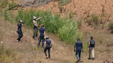 PA Media Police officers are seen at the site of a remote reservoir in The Algarve, Portugal, where a search is underway for evidence related to the disappearance of Madeleine McCann