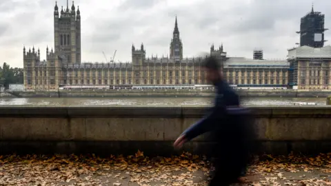 Getty Images Figure walking in front of Westminster Parliament