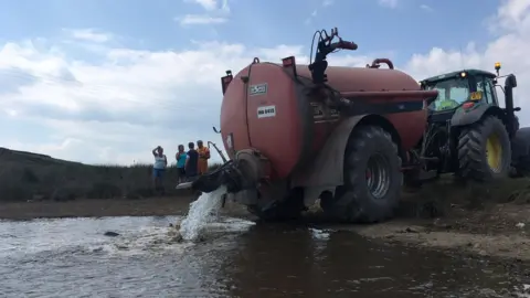 tanker refilling a watering hole