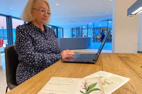 A woman works on a laptop