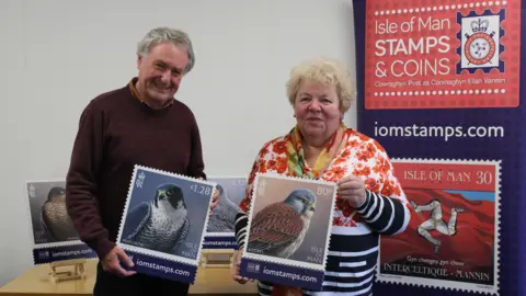 IOMPO Jeremy Paul and Maxine Cannon with copies of the stamps