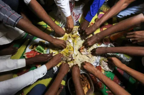 AFP People eat from from a communal plate.