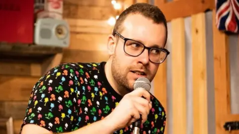 Andrew L Price Photography Gareth Morris with a microphone in his hand.