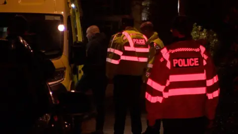 Police staff and charity workers by a police van