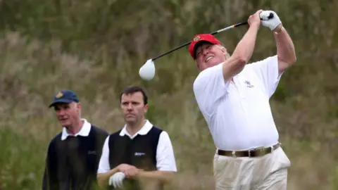 Donald Trump tees off from the third after the opening of The Trump International Golf Links Course on July 10, 2012 in Balmedie, Scotland.