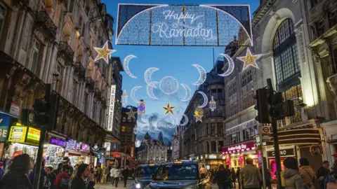 Reuters Happy Ramadan lit up in lights in Piccadilly as people look on and a taxi drives past