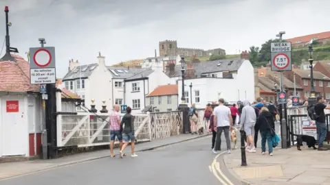 NYCC People walking across the historic swing bridge in Whitby