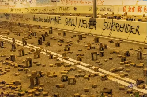 Getty Images HONG KONG, CHINA - NOVEMBER 18: Protesters use bricks to barricade near Hong Kong Polytechnic University in the Tsim Sha Tsui district on 18 November 2019 in Hong Kong