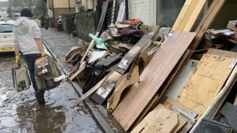 BBC Flooring business with flood damaged goods piled up outside in Nantgarw, Rhondda Cynon Taff