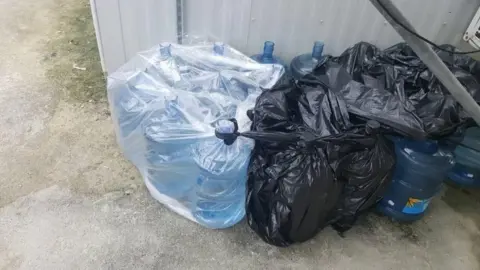 ABDUL AZIZ ADAM A collection of water bottles at Manus detention centre