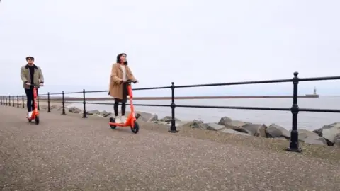 Neuron Mobility Two people on the scooters at the coast