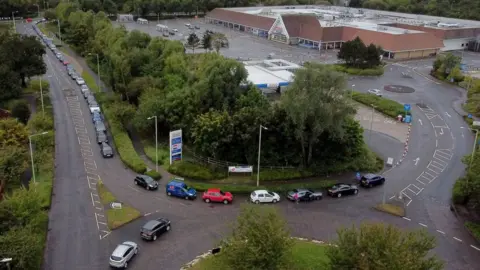 PA Media Long queue for fuel at a Tesco petrol station in Ashford, Kent, on Sunday