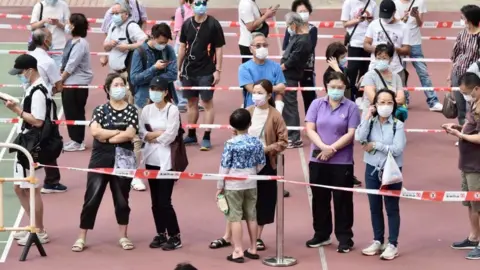 China News Service via Getty Images People line up for coronavirus testing at a temporary testing centre in Hong Kong on 9 November