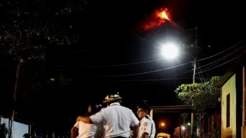 EPA Several firefighters help the residents to evacuate the little village of El Rodeo, due to the eruption of Volcan de Fuego (Volcano of Fire), in the town of Escuintla, Guatemala, 19 November 2018.