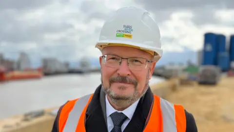Shaun Whitmore/BBC Graham Plant wearing a Third River Crossing hard hat and hi-vis vest