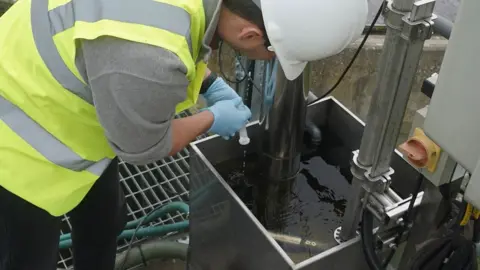 University of York Scientist takes a water sample in York