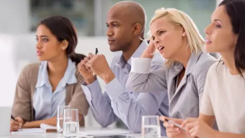 Getty Images Businesswoman looking confused during a meeting with her colleagues