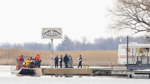 Reuters Police and firemen carry a bag off their search boat from the marshland in Akwesasne, Quebec, Canada