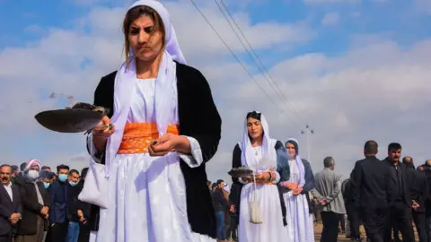 Getty Images Women burn incense during a procession at the mass funeral in Kocho on 6 February 2021