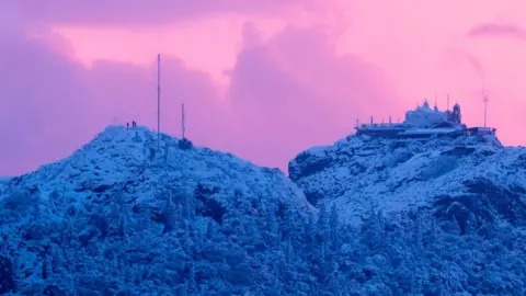 AFP This picture shows the hill of Lycabettus with people braving rare heavy snowfall in the city of Athens