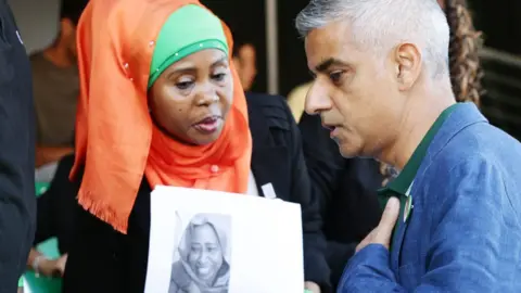 PA Family member of a victim of Grennfell Tower fire with London Mayor Sadiq Khan