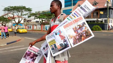 AFP A man selling papers in Liberia's capital, Monrovia - 29 December 2017