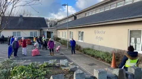 Patients queue outside the Ty Doctor surgery in Nefyn