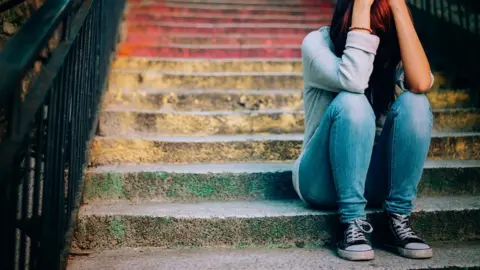 Getty Images Lonely teenager on stairs - generic image