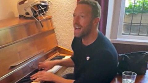 Coldplay frontman Chris Martin playing a pub piano