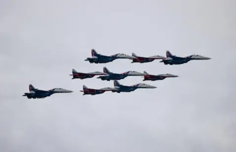 Reuters View from below of Russian fighter jets flying in formation during a flypast at the military parade in Moscow.