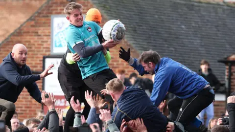Several young men in sportswear compete to grab the Shrovetide ball