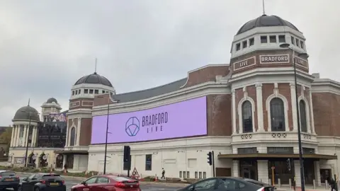 Purple Bradford Live sign placed on outside of building