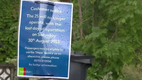 BBC A laminated sign tied to a post with cable ties. It has a blue background with white text, It says 'Customer notice - the 25 will no longer operate, with the last day of operation on Saturday 30th August 2025. Passengers may be eligible to use the 'steps' service as an alternative, please phone 01793 855550 for further information'
