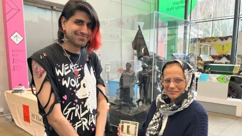 Ibrahim Chisti and his mother Sharon holding a photo of her father, Charlie.