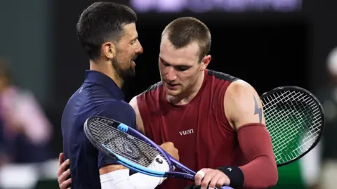 Novak Djokovic and Jack Draper hug at the net after their match at Indian Wells 