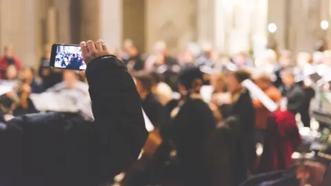 Manuel Breva Colmeiro/ Getty Images A phone being held up to film a concert