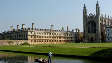 PA Media Three people on a punt on the Backs in Cambridge as it passes King's College.