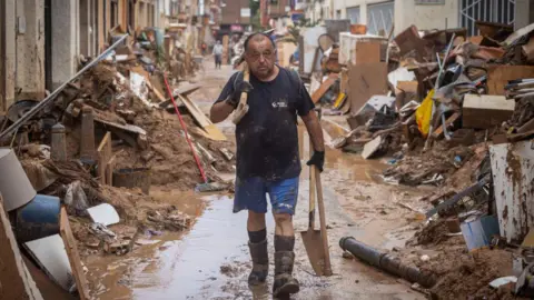 Getty Images A man cleans his house after heavy rain and flooding hit large parts of the country on November 04, 2024 in Paiporta, Spain