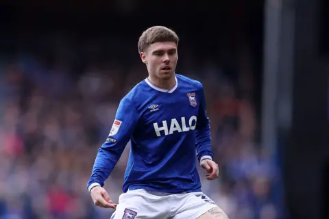 Leif Davis, wearing blue and white Ipswich Town strip, in action during a match.