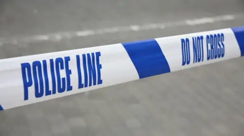 Cordoned off police line by blue and white tape