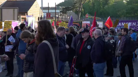 PA Media Dozens of people rallying outside a bins depot in support of Birmingham council workers. Many are carrying union flags or placards, including one saying: "Victory to the bin workers"