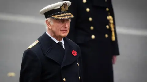 PA Media King Charles the Royal Navy uniform of the Admiral of the Fleet, with a red poppy brooch on his coat, during last year's Remembrance Sunday service at the Cenotaph in London